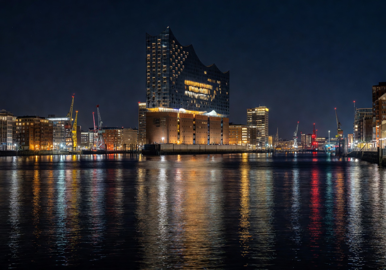 Hamburg harbor and Elbphilharmonie concert hall at night with city lights reflected on water